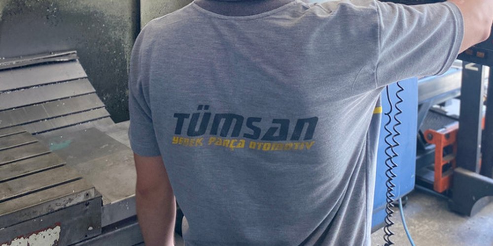 Tümsan tişörtlü bir çalışan üretim tezgâhı başında