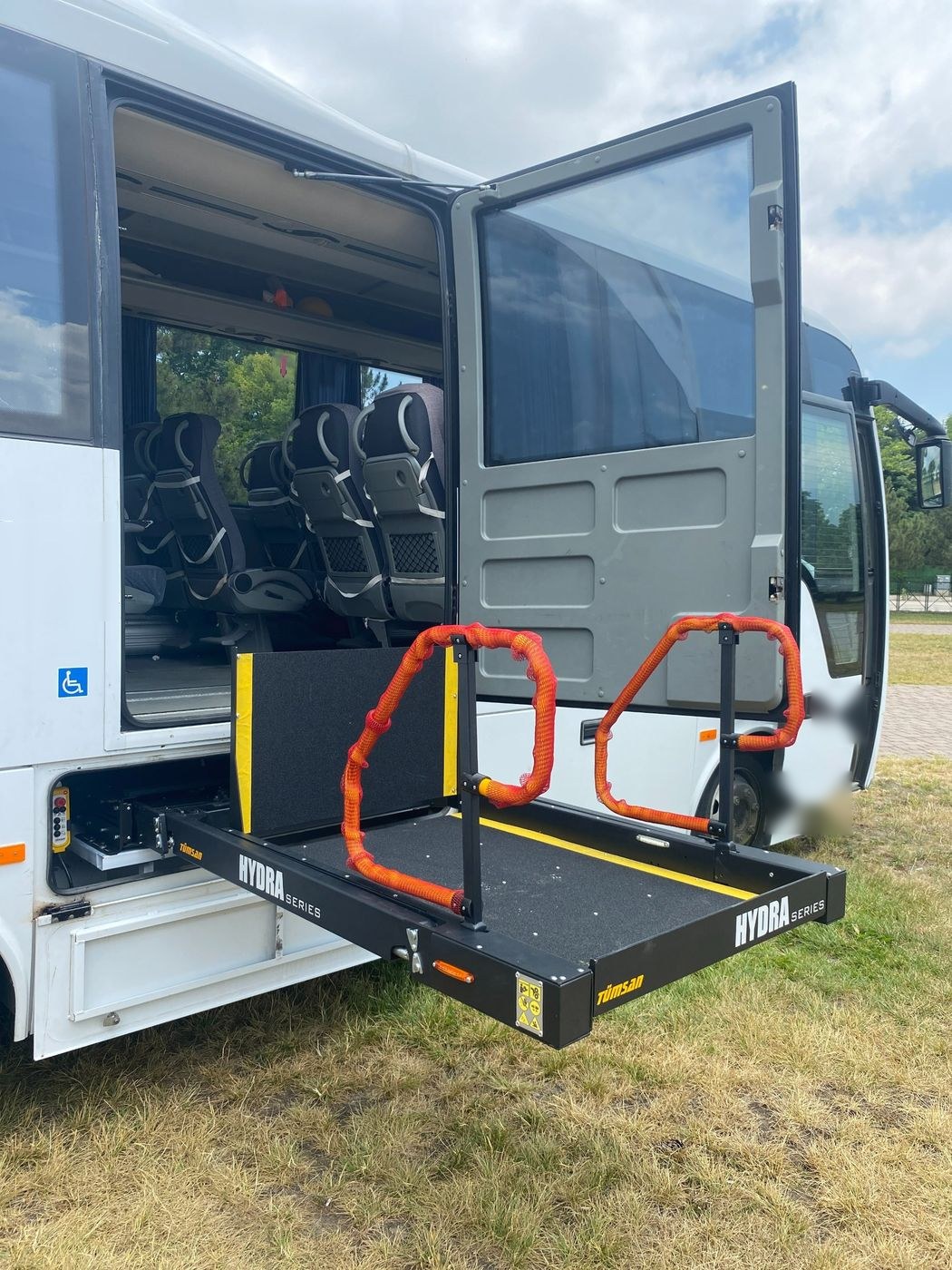 Beyaz midibüsün yan kapısında açılmış HYDRA serisi lift platformu