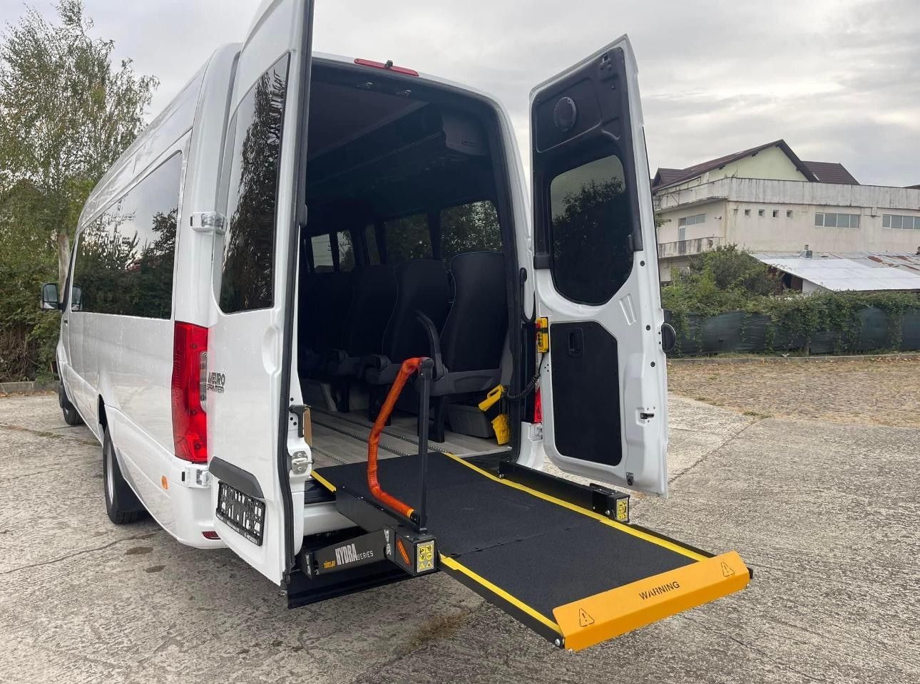 Arka kapısı açık beyaz Sprinter minibüste HYDRA serisi lift ve sarı uyarı kapağı