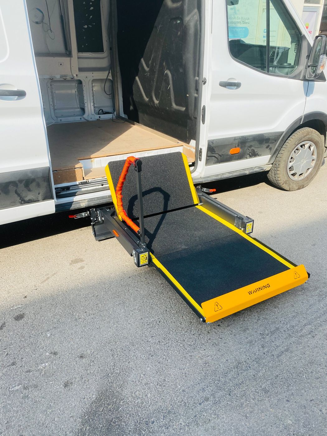 Panelvanın yan kapısında katlanır rampalı lift platformu