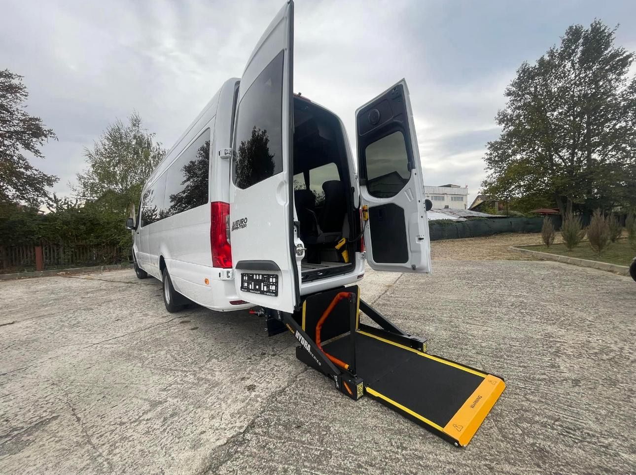 Beyaz Sprinter'ın arkasında zemine inmiş HYDRA serisi lift